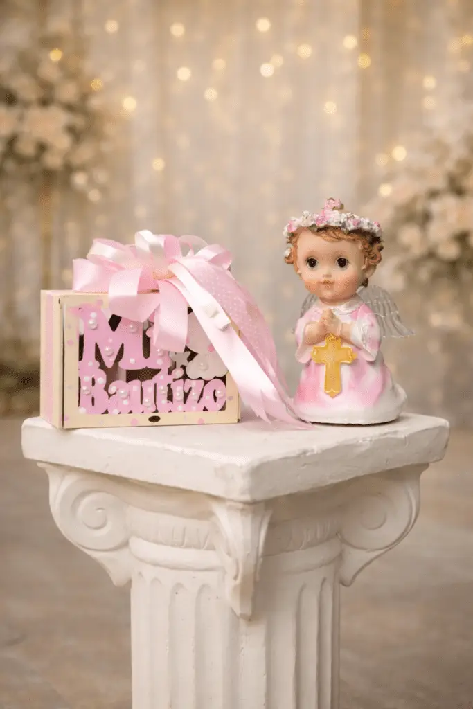 Recuerdo de bautizo en tonos rosa con figura de ángel y caja decorativa personalizada.